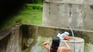 Indian village girl bathing near water tank outdoor